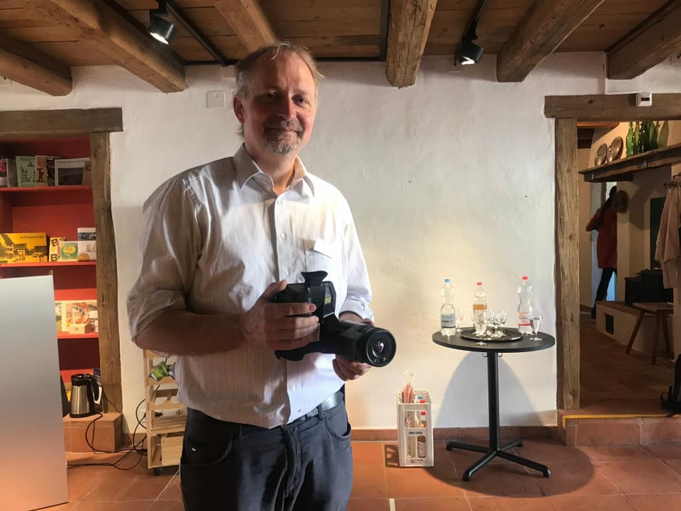 Kantonsarchäologe Reto Marti hält eine Kamera in der Hand. 