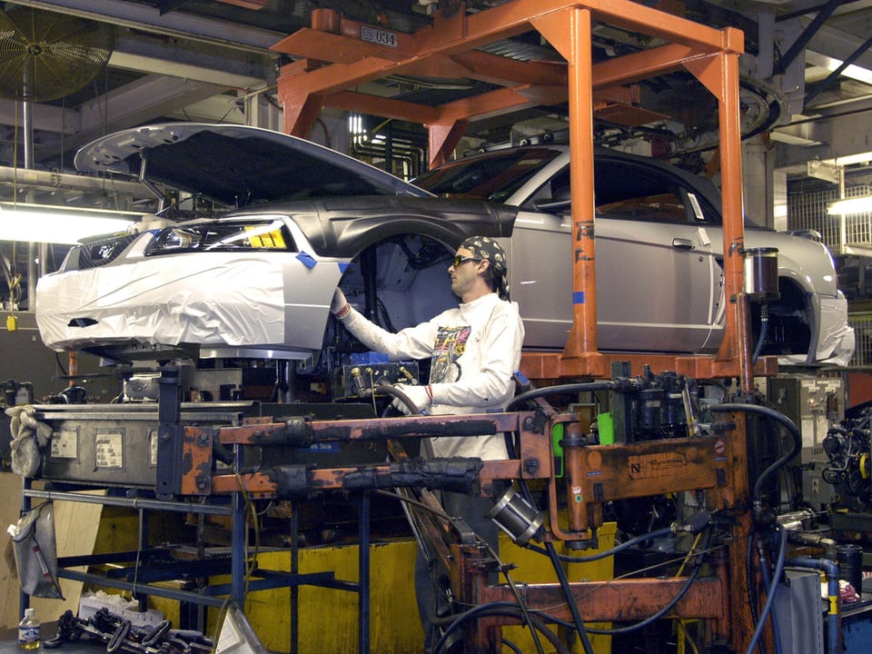 Ein Mann montiert ein Auto in einem heutigen Ford-Werk.