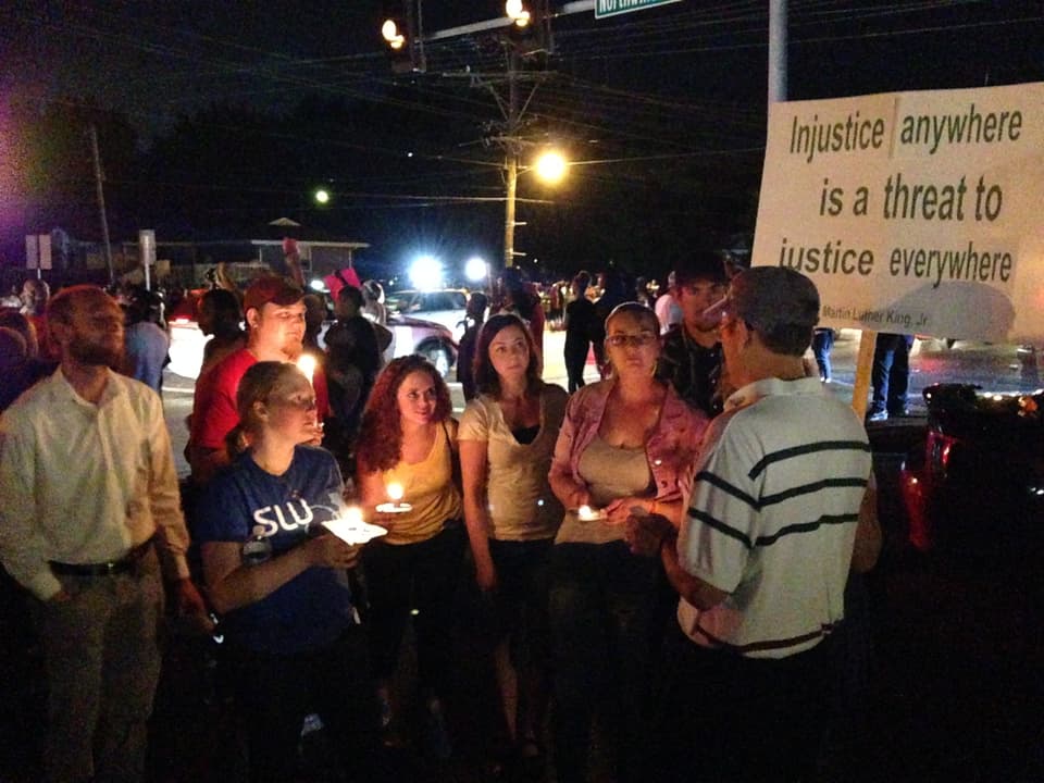 Demonstranten mit Plakaten und Kerzen in der Nacht