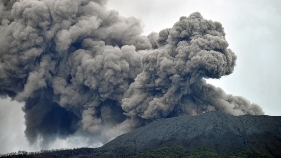 Der aktive Vulkan Marapi stösst eine dunkelgraue Rauch- und Aschewolke aus.