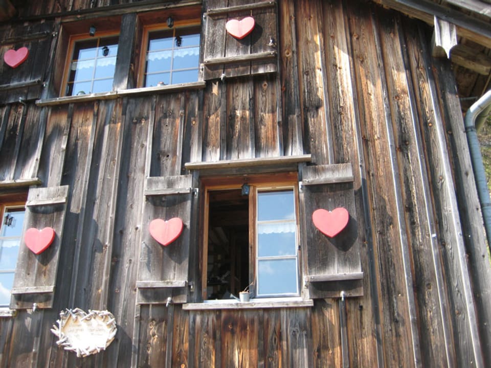 Herzen an den Holzfenstern der Alp.