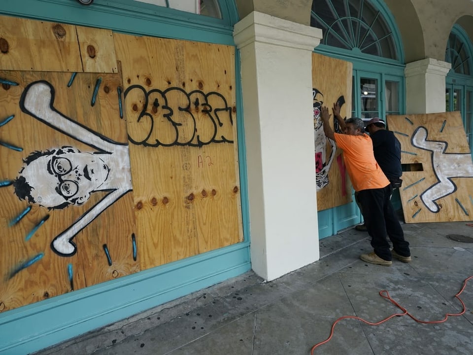 Arbeiter verbarrikadieren ein Geschäft im French Quarter von New Orleans.