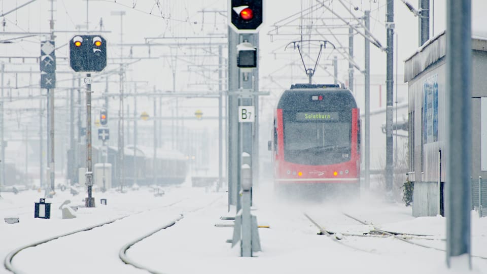 Ein Zug im winterlichen Bahnhof Oensingen.