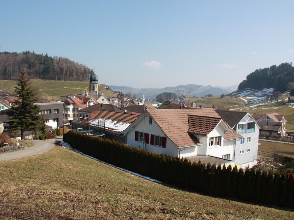 Blick von oben auf die Häuser eines Dorfes an einem sonnigen Frühlingstag.