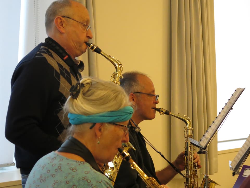 Zwei Männer und Frau mit Saxofon