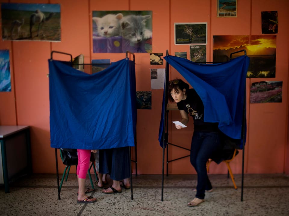 Frauen bei ihrer Stimmabgabe in einem Lokal. 