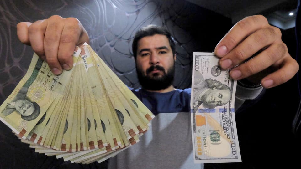 Ein Geldwechsler in Teheran mit Dollar-Noten und dem iranischen Real. 