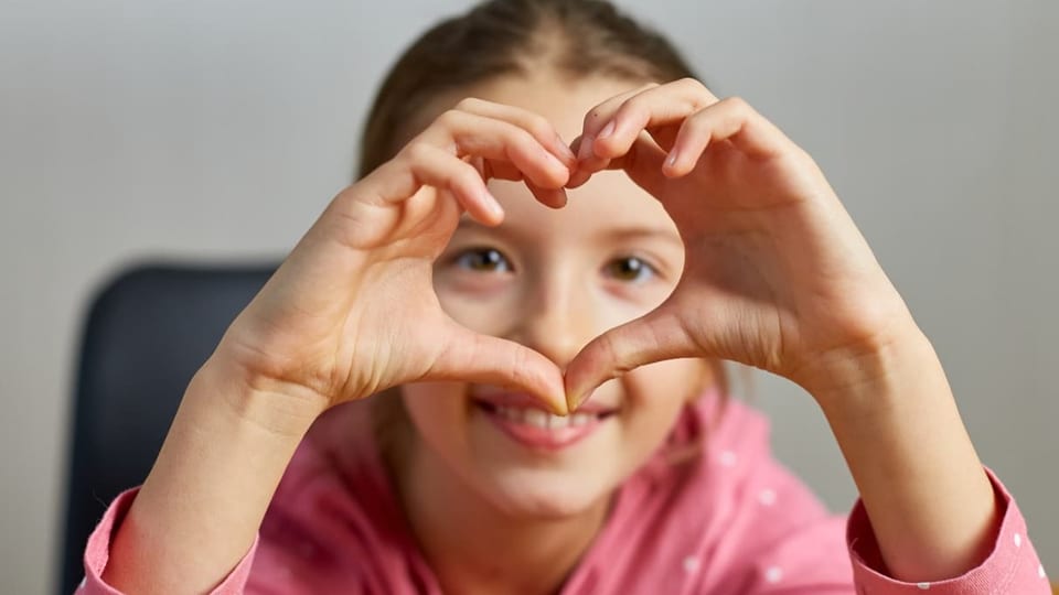 Dank SRF Kids wird es nie langweilig Ein Mädchen formt mit ihren Händen ein Herz