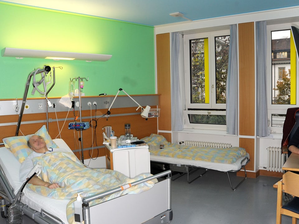 Patient in einem grün-blau gestrichenen Zimmer.