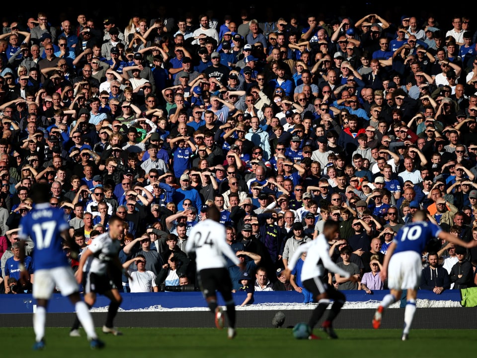 Zuschauer im Stadion von Everton werden von Sonnenschein geblendet.