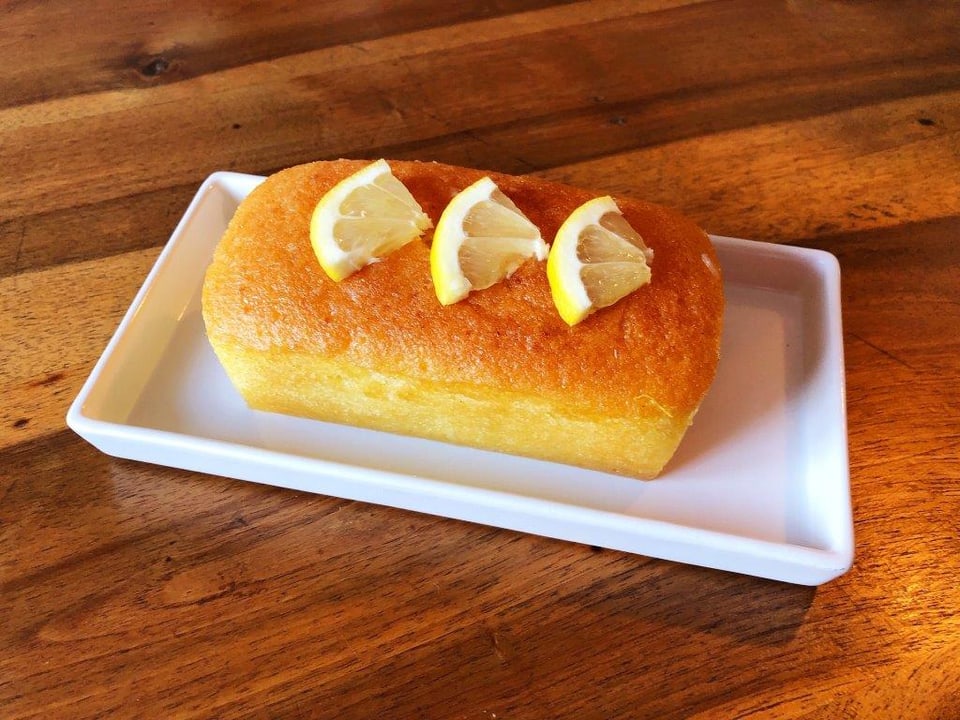 Ein kleiner Zitronenkuchen auf einem Holztisch.