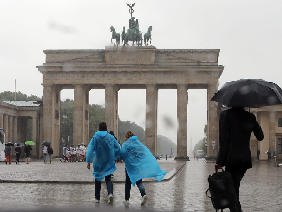 Brandenburger Tor, Menschen mit Regenschutz.