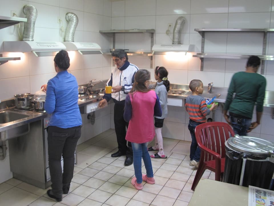 Frauen, Männer und Kinder in einer Küche