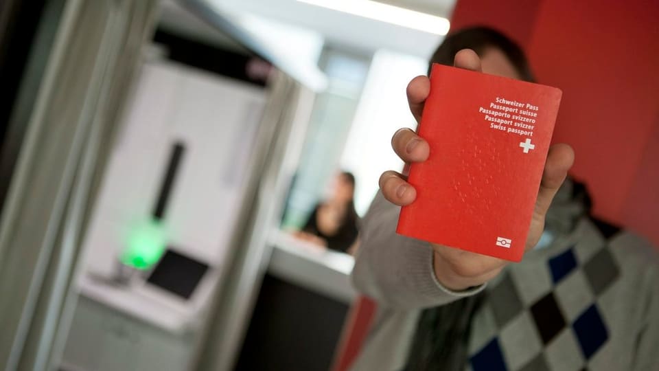 Mann hält roten Schweizer Pass in Kamera