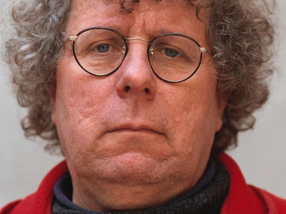 Loderer trägt eine Brille mit einem leichten Gestellt, seine grauen Locken fallen ihm in die Stirn.