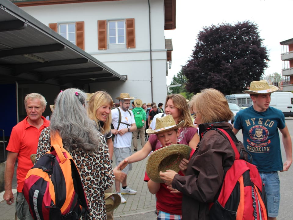 Verschiedene Wanderinnen und Wanderer warten vor dem Bahnhof in Stein am Rhein auf den Abmarsch.