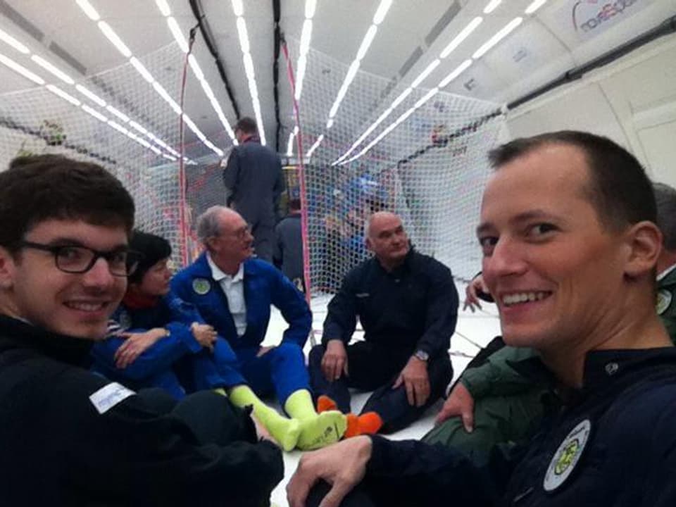 Michael Weinmann zusammen mit anderen Personen im Flugzeug sitzend