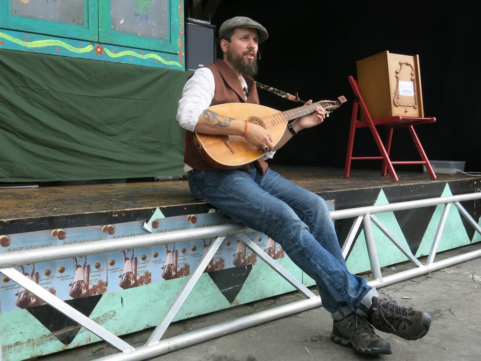Oliver Kayser mit einer mittelalterlichen Laute auf einer kleinen Bühne.