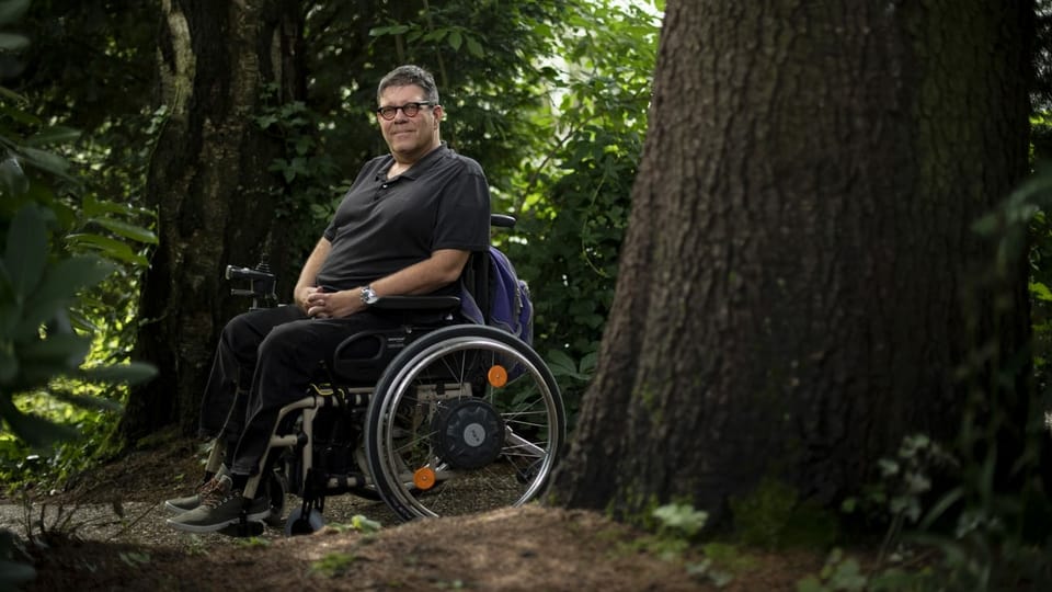 Ein Mann im Rollstuhl umringt von Bäumen