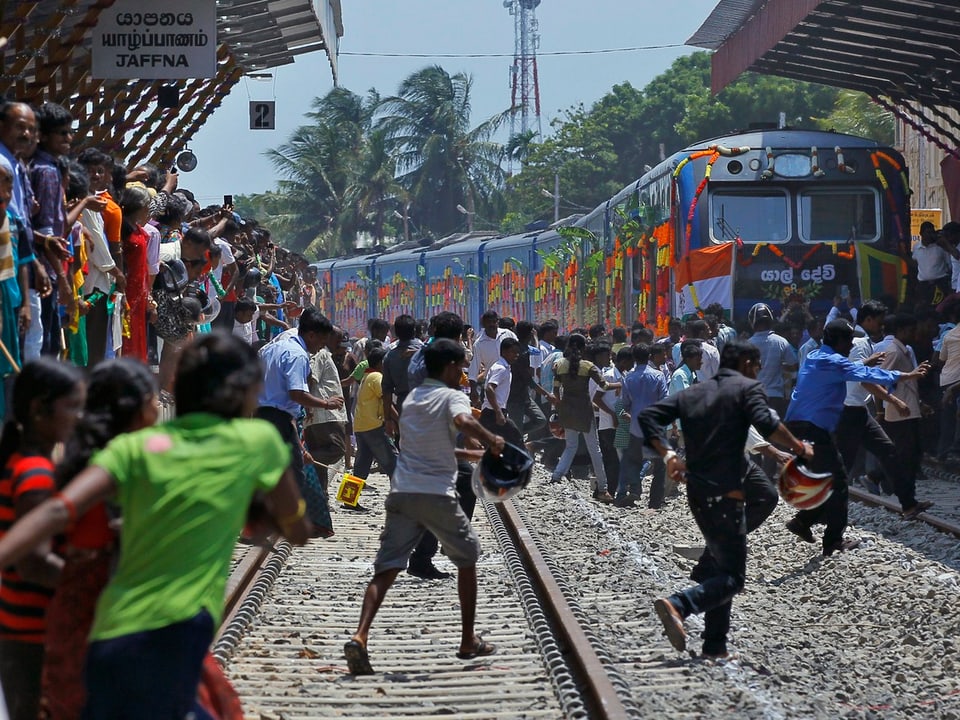 Menschen rennen auf dekorierten Zug im Bahnhof zu