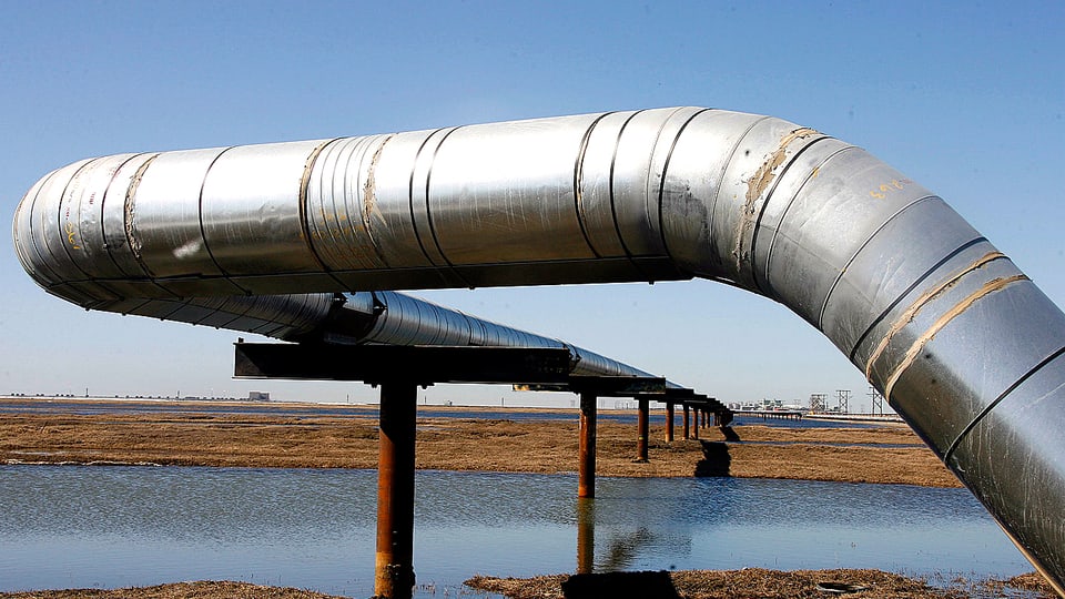Eine Pipeline führt über ein Flussbett in Alaska.