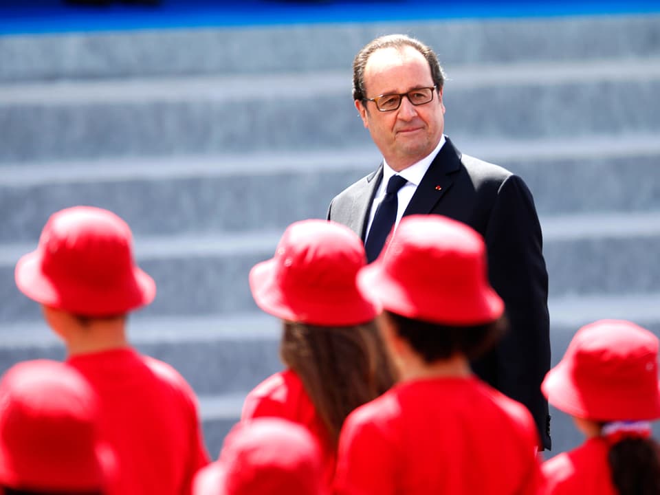 Rot gekleidete Hostessen defilieren vor Hollande.
