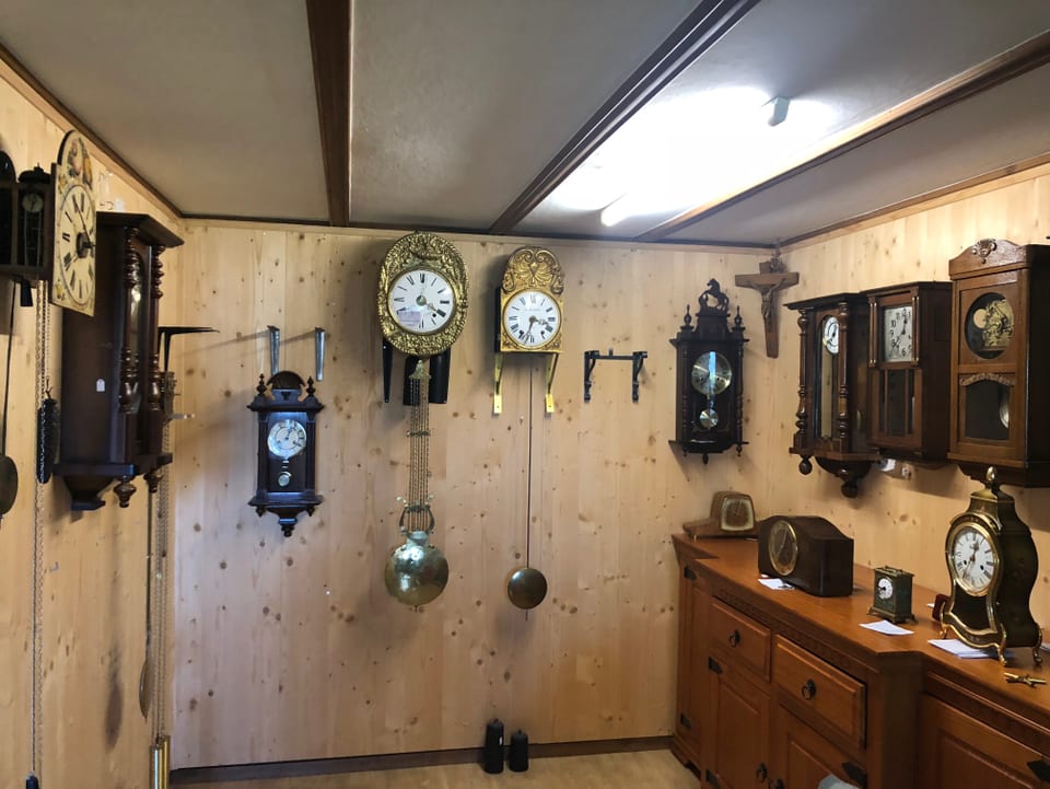 Alte Uhren hängen an einer Wand oder stehen auf einem Möbel.