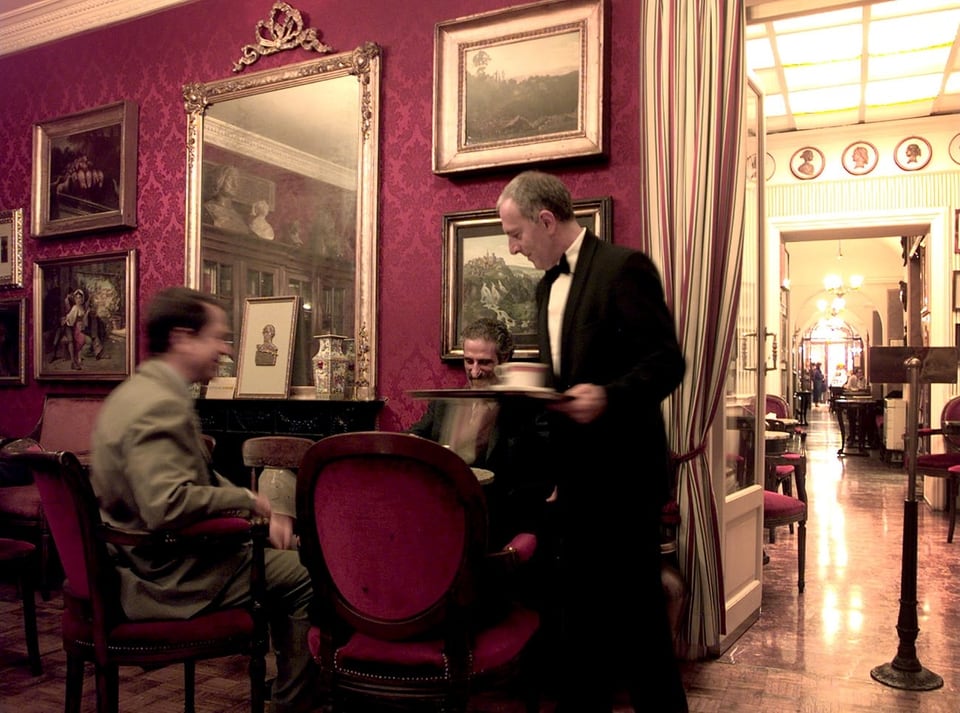 Ein Kellner und zwei Gäste Im Inneren des Caffè Greco.