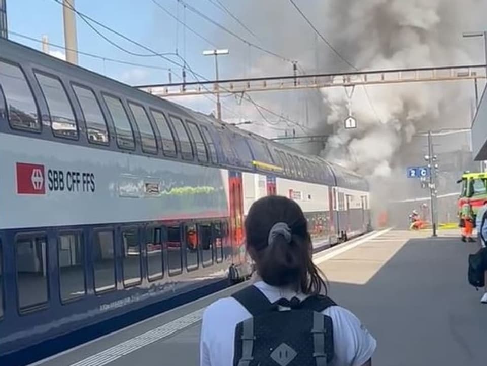 Eine Passantin beobachtet den brennenden Zug in Altstetten.