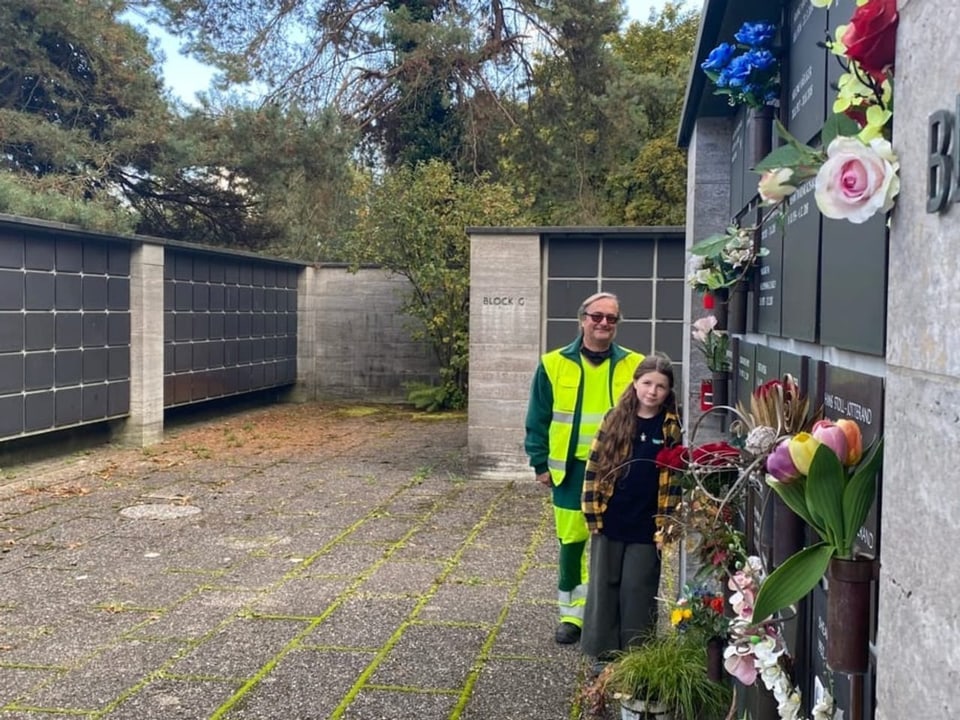Daniel und Elin stehen neben der Nischenwand im Friedhof Nordheim