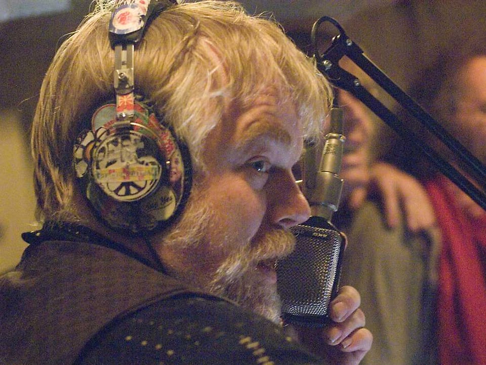 Hoffman mit Kopfhörern an einem Radiomikrofon.