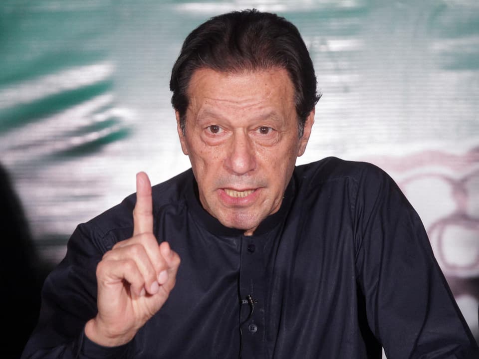 Imran Khan spricht bei einer Medienkonferenz. Er hat einen Zeigfinger erhoben.