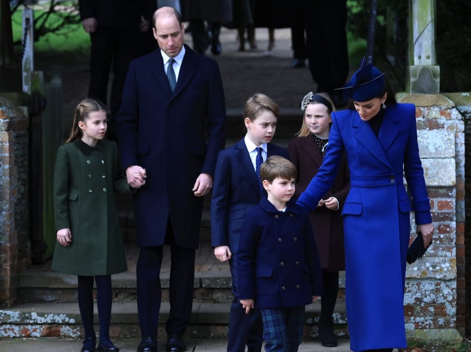 Prinz William und Prinzessin Kate stehen mit ihren drei Kindern und einem Mädchen auf einer kurzen Treppe.