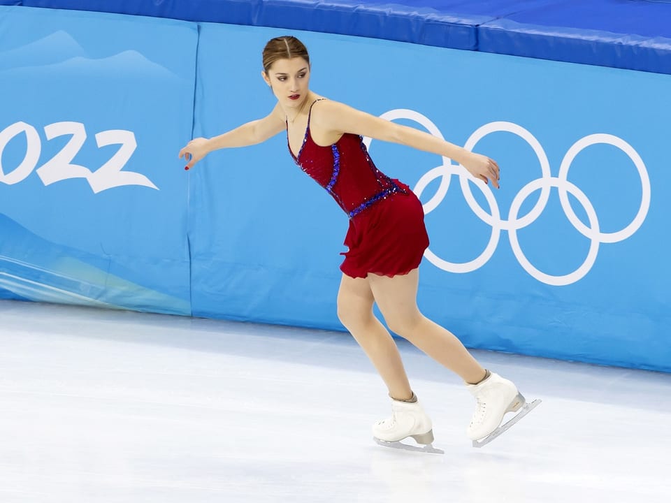 Patinadora artística com vestido vermelho nos Jogos Olímpicos.