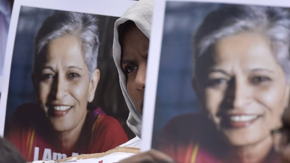 Eine Frau hält bei einem Protest ein Foto der getöteten Journalistin Gauri Lankesh in die Luft.