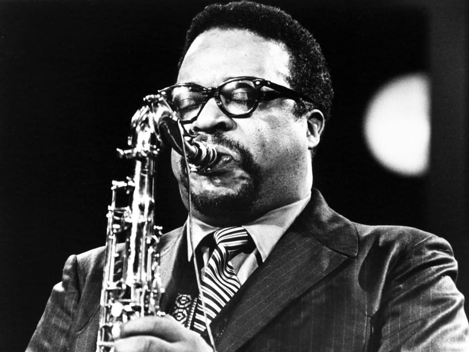 Gene Ammons trägt eine Brille. Er spielt Saxofon.