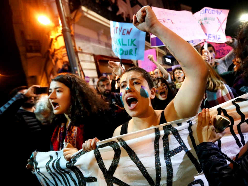 Frauen recken die Fäuste und tragen ein Transparent in den Strassen Istanbuls.