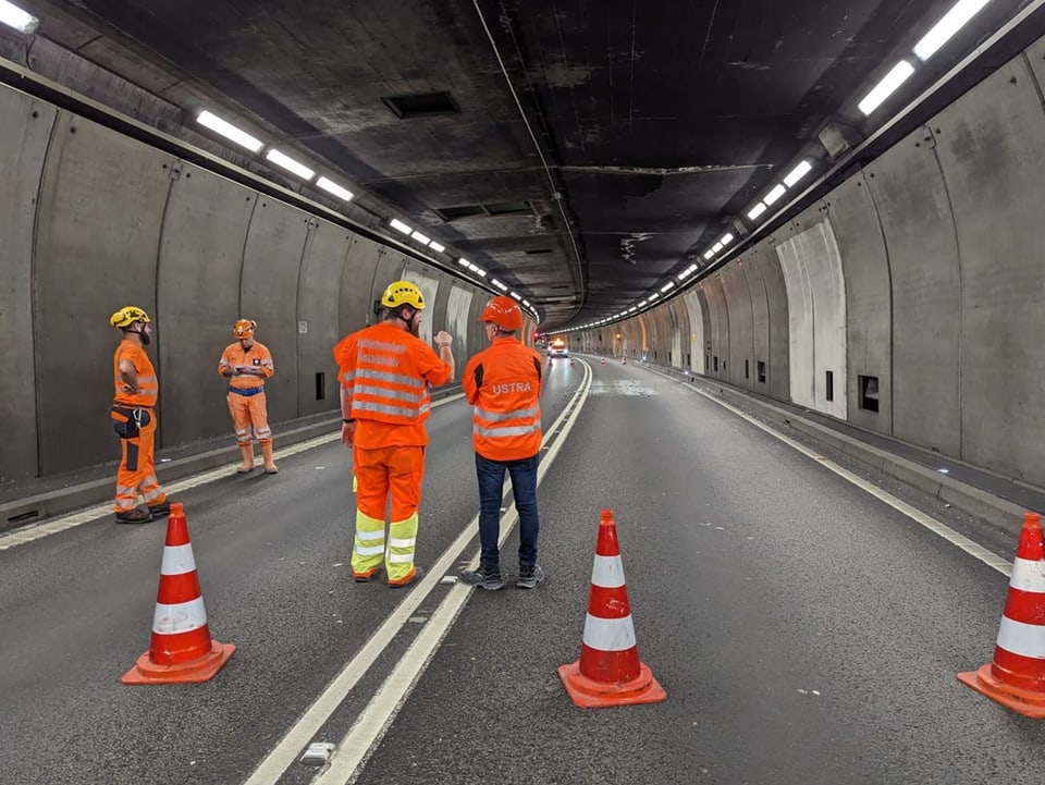 Bauarbeiter begutachten den gut 25 Meter langen Riss an der Decke des Gotthardstrassentunnels.