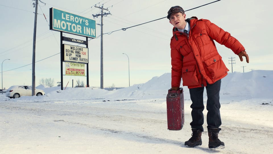 Lester geht mit einem Koffer auf Schnee.