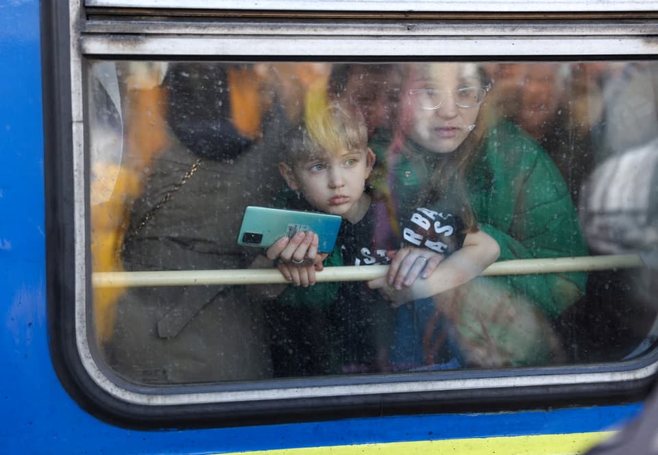 Eine Frau und ihr Sohn steigen am 25. Februar am Kiewer Hauptbahnhof aus einem Evakuierungszug von Kiew nach Lwiw aus.