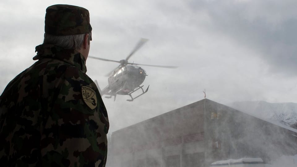 Soldat schaut einem Militärhelikopter bei der Landung zu. 