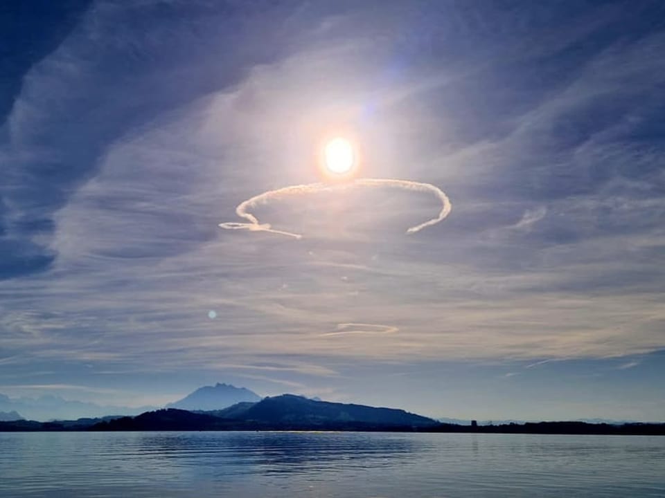 Schleierwolken mit halbkreisförmigem Kondensstreifen.