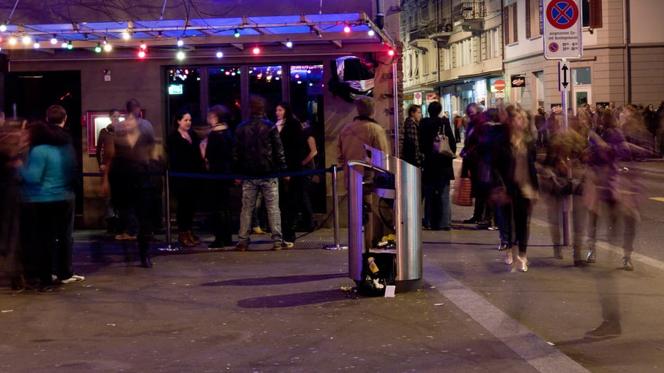 Menschenmenge vor einer Bar an der Zürcher Langstrasse bei Nacht.