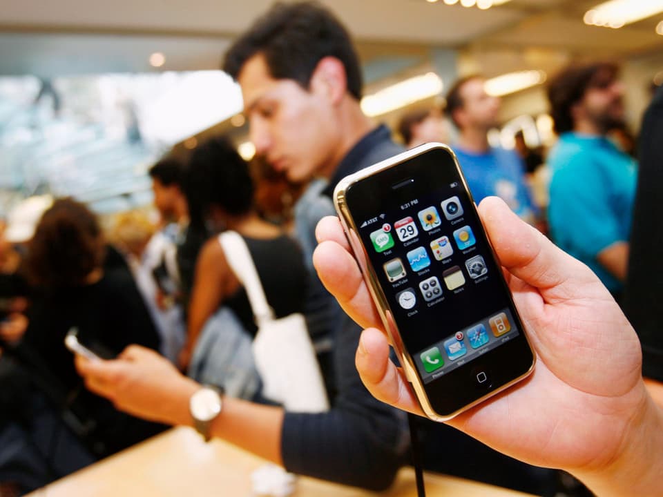 Jemand hält in einem Apple-Store das iPhone 3G vor die Kamera.