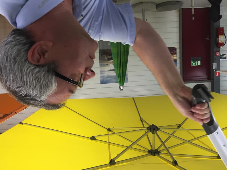 CEO Markus Glatz erklärt eine neue Erfindung an einem Sonnenschirm.