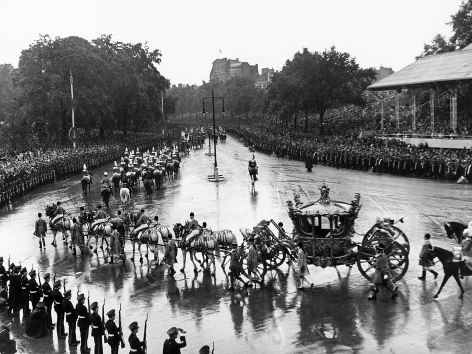 Königliche Kutsche mit Eskorte fährt vor dem Buckingham Palace vor.