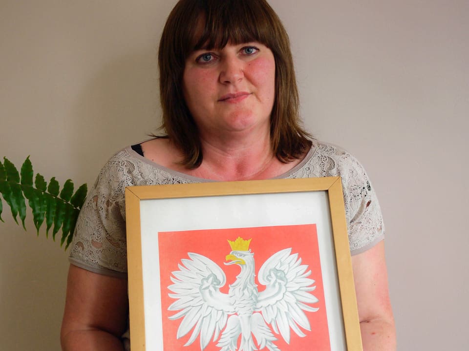 Eine Frau präsentiert ein national-konservatives Adler-Bild.