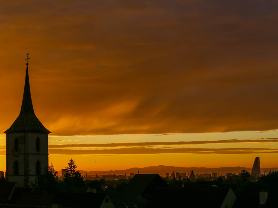 Blick auf eine Kirche mit gelb-orangen Himmel im Hintergrund.