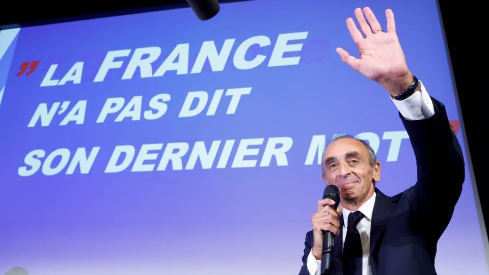Zemmour steht vor einer Aufschrift «La France n'a pas dit son dernier mot» und winkt