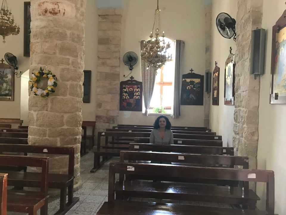 Fida Jiryis sitzt auf einer Bank in der Sankt Elias Kirche in Fassuta.